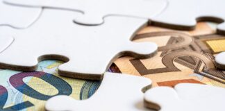Jak ograniczyć ryzyko kursowe przy imporcie rozliczanym w dolarach i euro Banknoty euro widoczne spod puzzli symbolizujących rozwiązania finansowe