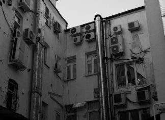Elewacja bloku z licznymi jednostkami klimatyzacji i instalacjami