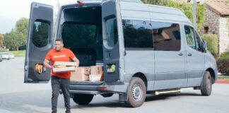 Kurier w furgonie dostawczym rozwozi paczki w dzielnicy podmiejskiej