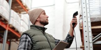Inwentaryzacja magazynu krok po kroku – checklista dla hurtowni Pracownik hurtowni skanuje zapasy ręcznym skanerem i tabletem
